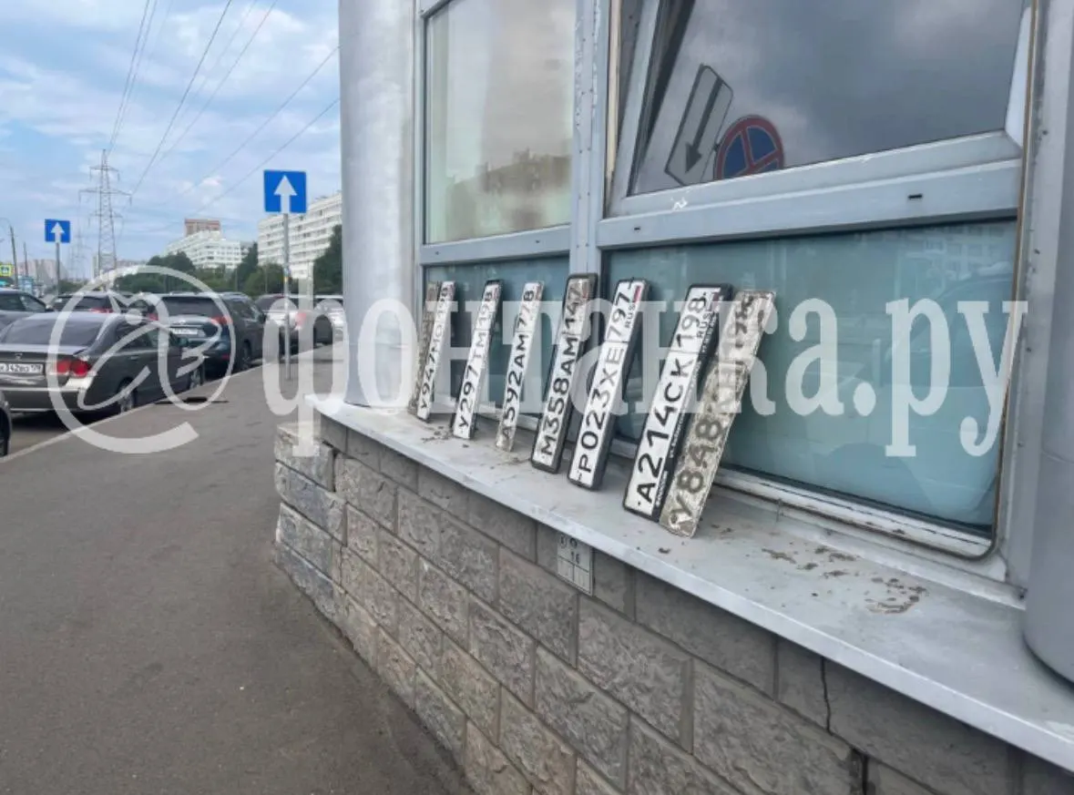 После субботнего ливня на Пионерской, Королёва, Новикова и других улицах Санкт-Петербурга жители и водители собирают оторванные регистрационные номера — следствия затопления.
