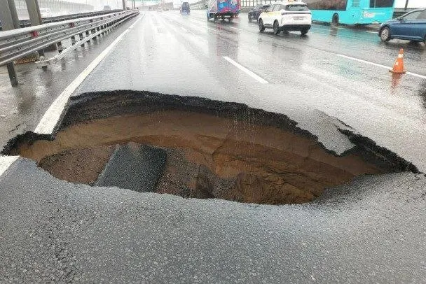 Из-за локального размыва дорожного полотна на КАД образовалась яма, движение затруднилось на нескольких километрах. Специалисты работают на месте.